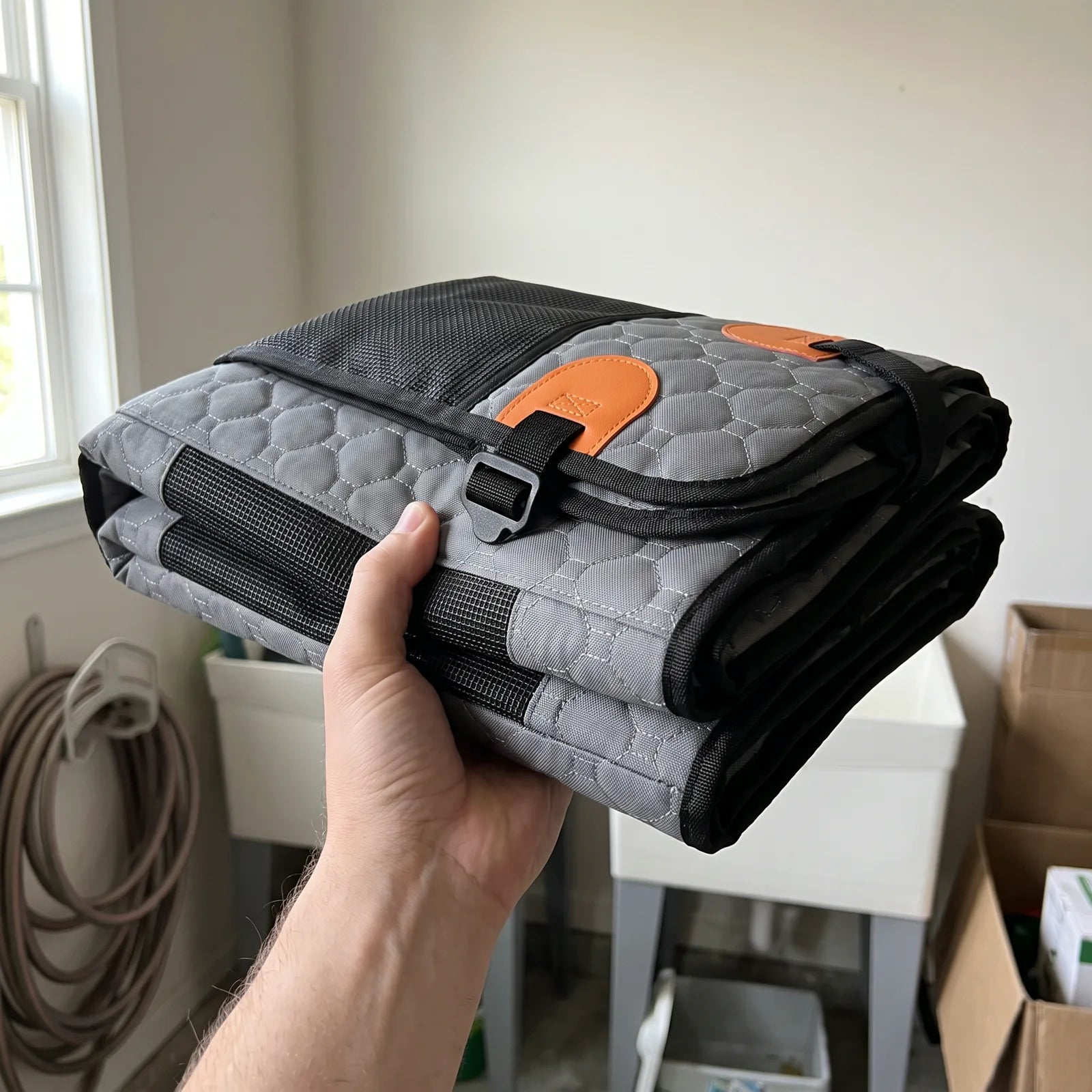 The Road Lounger folded flat and held in one hand
